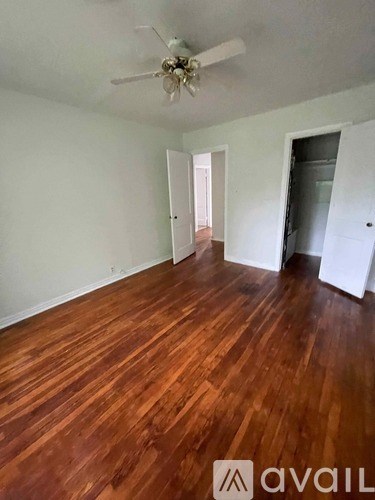 A room with wooden floors and a ceiling fan.
