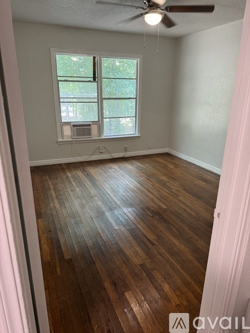 A room with wooden flooring and a window.