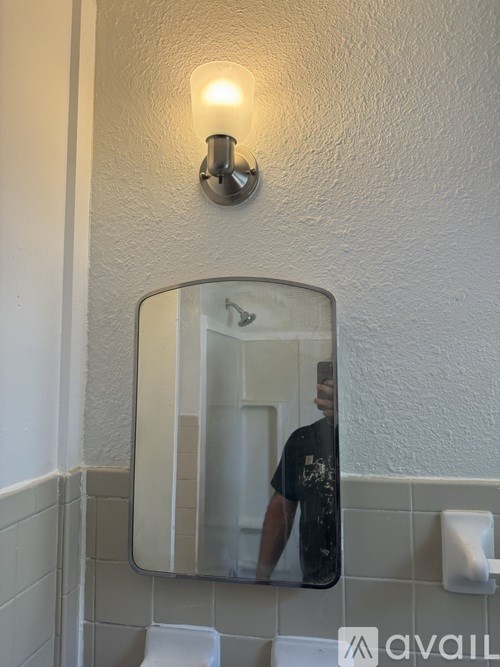 A man is taking a selfie in a bathroom mirror.
