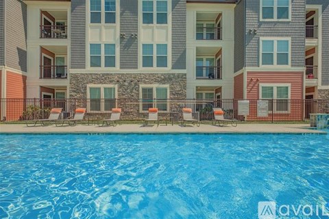 A large swimming pool in front of a multi-story apartment building.