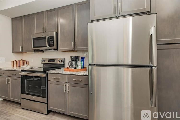 A kitchen with a stainless steel refrigerator, oven, and microwave.