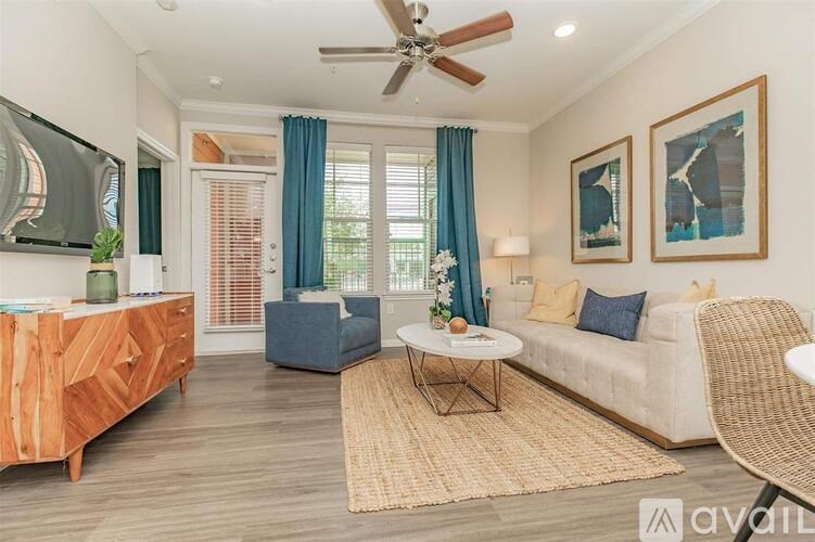 A living room with a sofa, a coffee table, a chair, and a television.