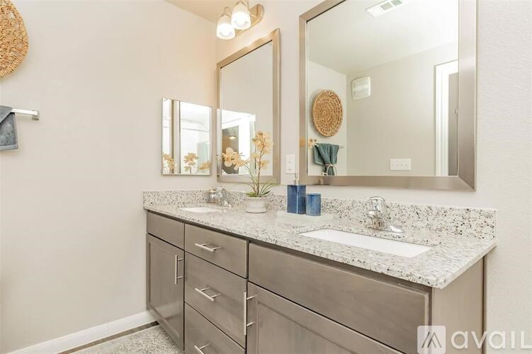 A bathroom with a vanity, sink, and mirror.