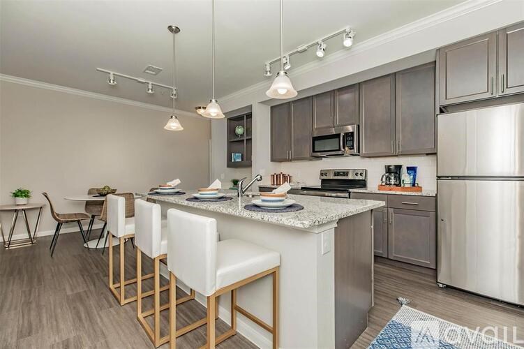 A kitchen with a white countertop and stainless steel appliances.