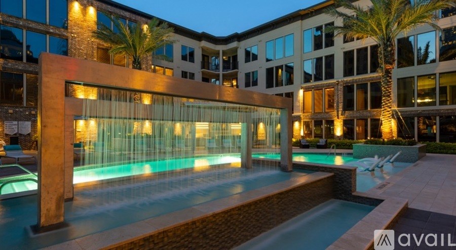 A modern building with a pool and palm trees.
