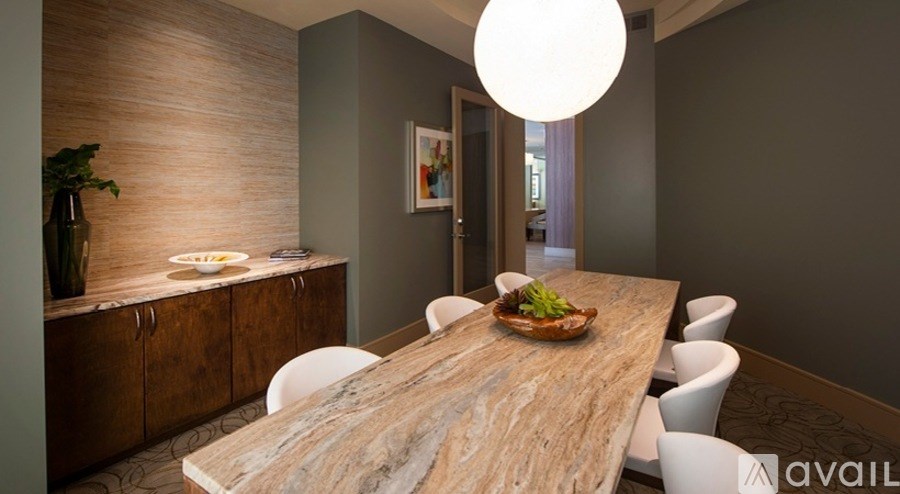 A dining room with a wooden table and white chairs.