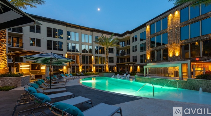 A modern building with a pool and lounge chairs.