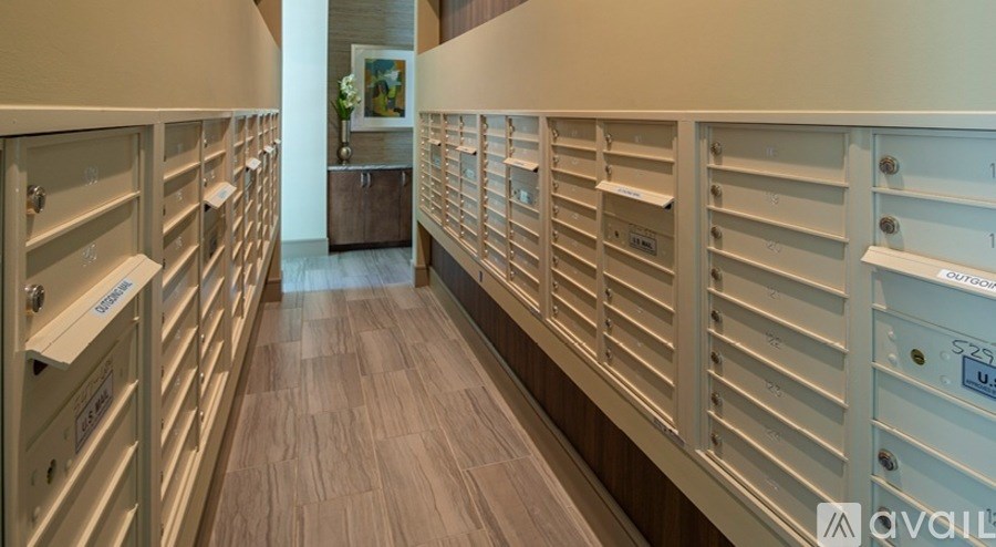 A long hallway with a row of mailboxes on the wall.