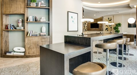 A modern living room with a wooden bookshelf and a grey sofa.