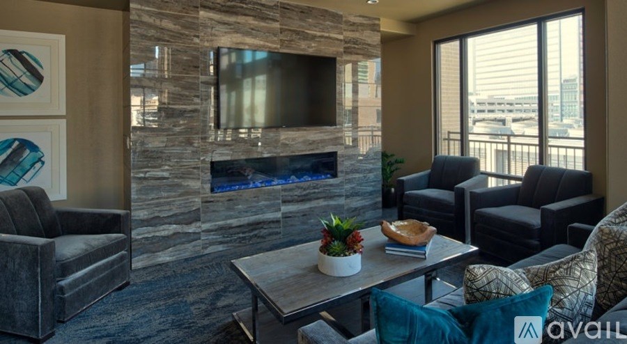 A living room with a stone fireplace and a flat screen TV.