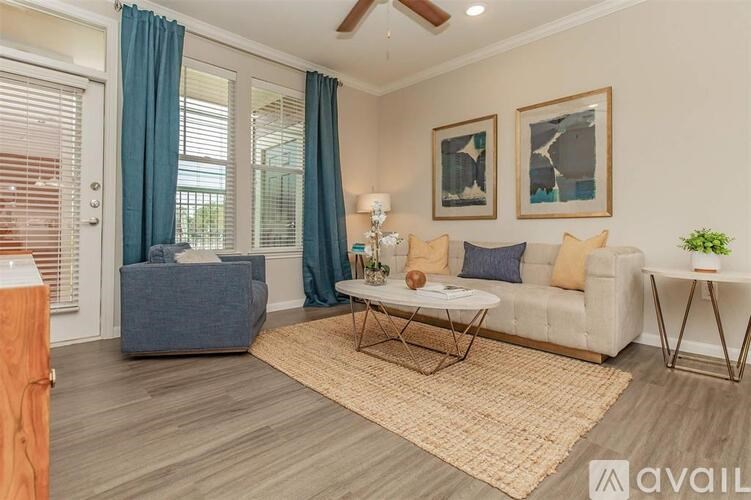 A living room with a grey sofa, a white coffee table, and a rug.