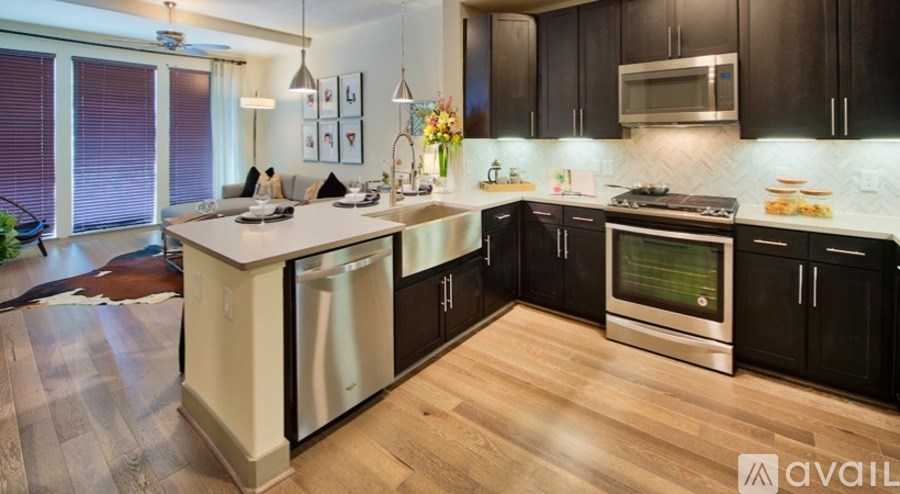 A modern kitchen with black cabinets and stainless steel appliances.