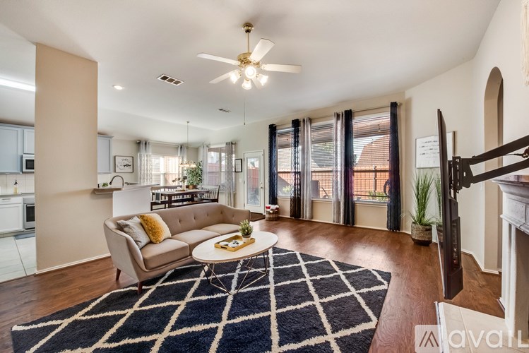 A living room with a beige couch and a black and white rug.