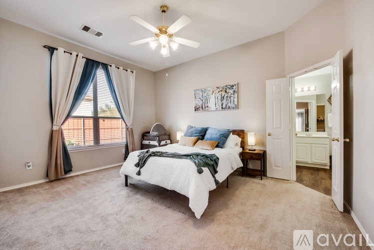 A bedroom with a large bed and a ceiling fan.