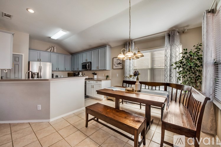 A kitchen with a table and chairs.