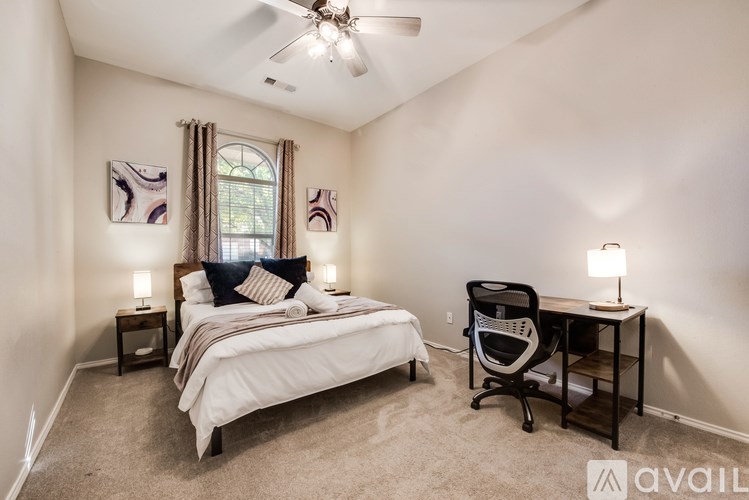 A bedroom with a bed, desk, and chair.