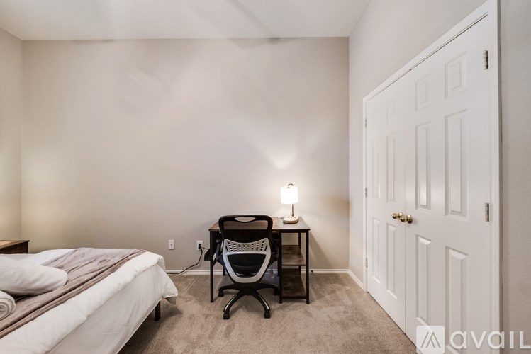 A bedroom with a bed, desk, and chair.