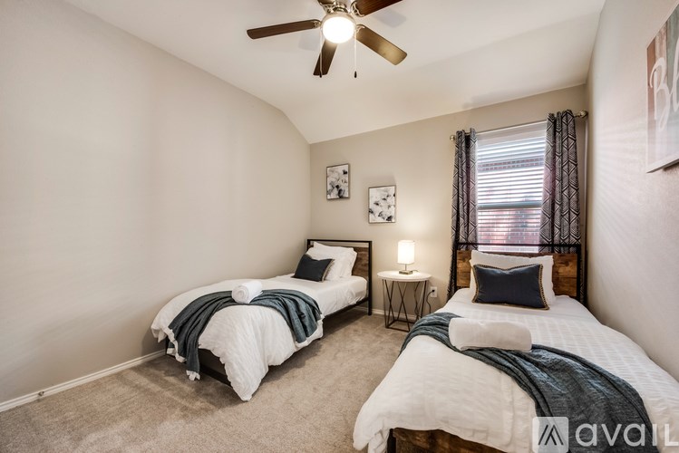 A bedroom with two beds and a ceiling fan.