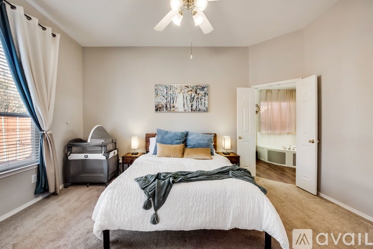 A bedroom with a large bed and a ceiling fan.