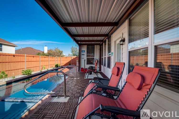 A pool and lounge chairs on a covered patio.