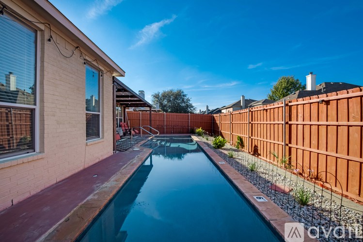 A small residential pool surrounded by a wooden fence.