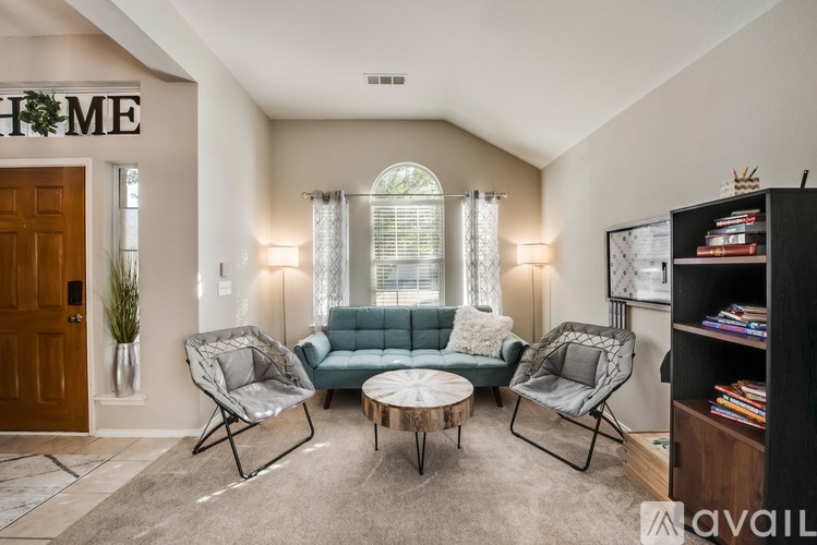 A living room with a sofa, two chairs, and a coffee table.