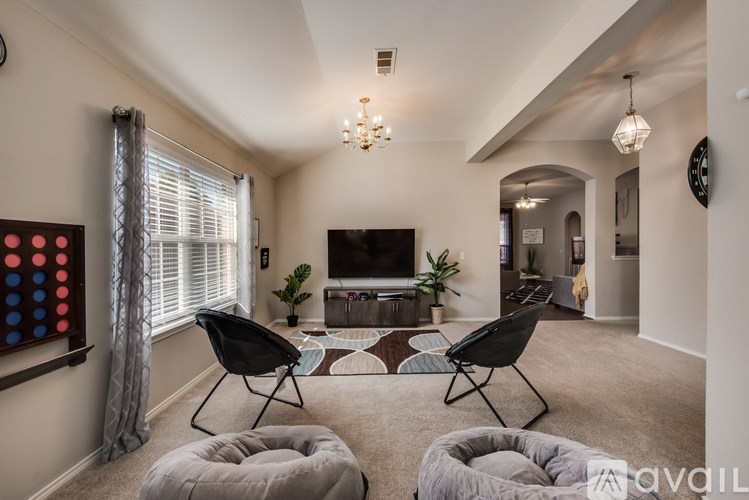A living room with a grey carpet and a black chair.