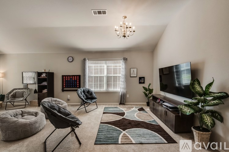 A living room with a TV, a chair, and a plant.
