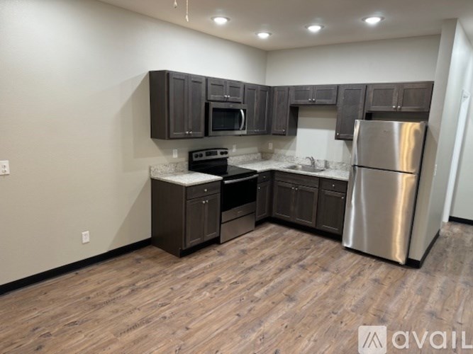 A kitchen with dark wood cabinets and stainless steel appliances.