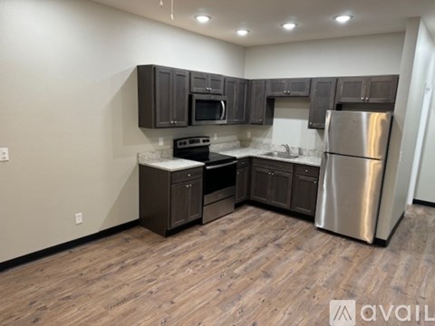 A kitchen with dark wood cabinets and stainless steel appliances.