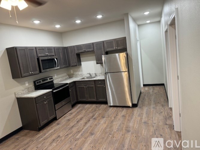 A kitchen with dark wood cabinets and stainless steel appliances.