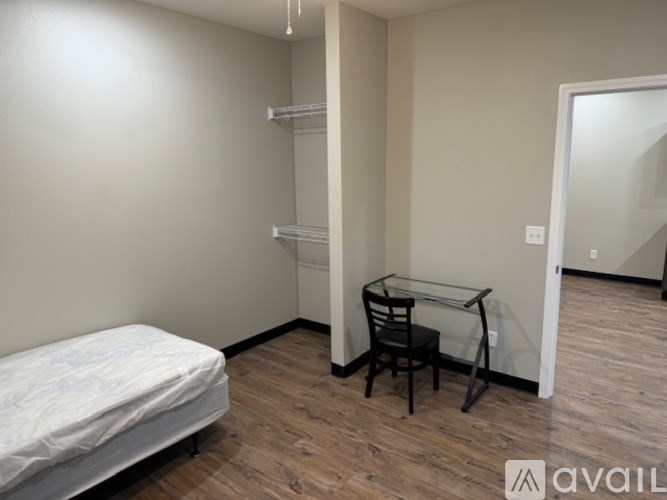 A bedroom with a bed, desk, and chair.