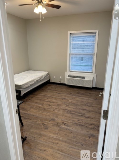 A room with a bed, a window, and a fan.