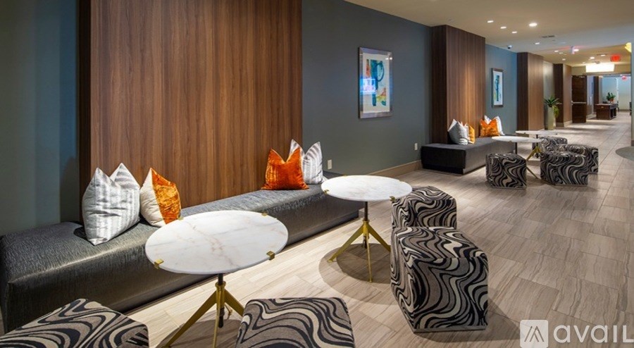 A modern living room with a variety of seating options and a wooden accent wall.