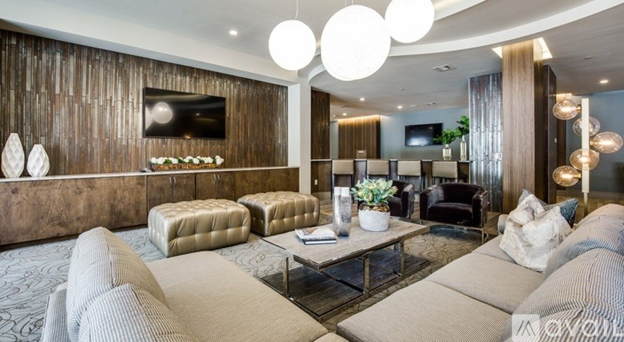 A modern living room with a large sectional sofa and a wooden wall.