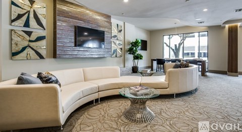 A living room with a white sofa and a glass coffee table.