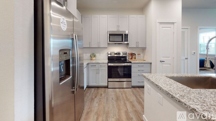 A modern kitchen with stainless steel appliances and white cabinets.