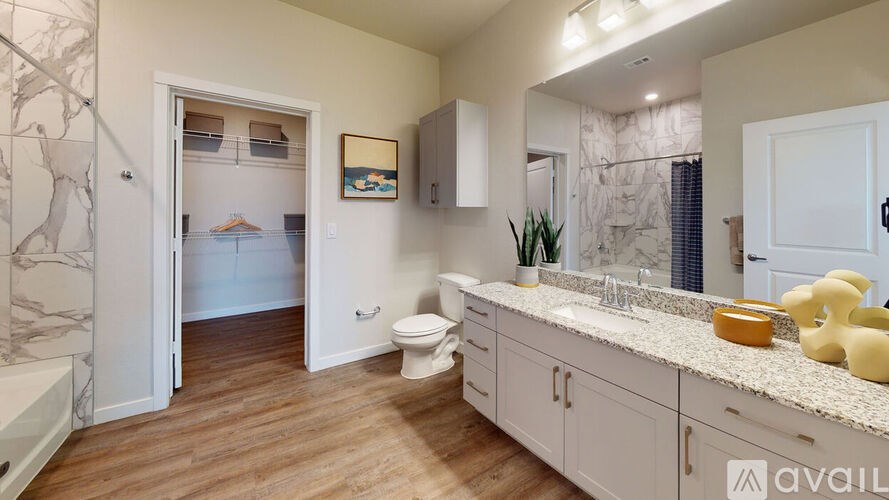 A bathroom with a toilet, sink, and a mirror.