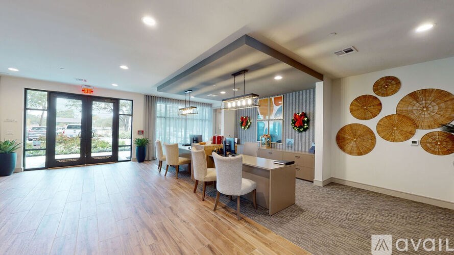 A spacious office with a reception desk and chairs, a large window with a view of the outside, and a wall decorated with circular patterns.