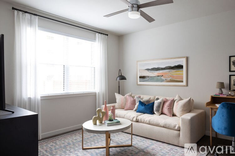 A living room with a couch, a coffee table, and a painting on the wall.