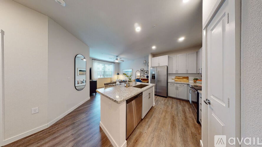 A kitchen with white cabinets and a wooden floor.
