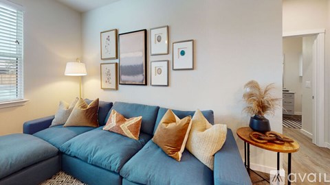 A living room with a blue couch and a lamp.