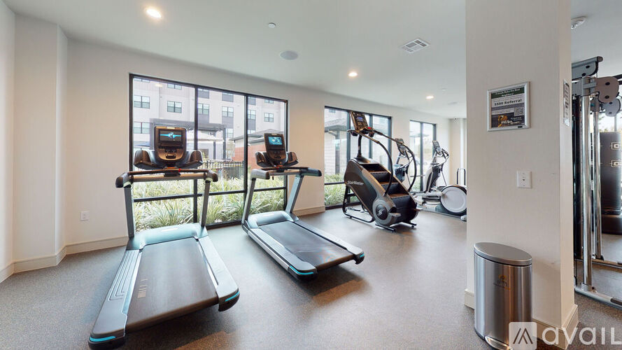 A gym with treadmills, elliptical machines, and a weight machine.
