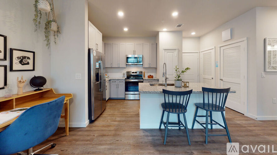 A kitchen with a blue chair and a fridge.
