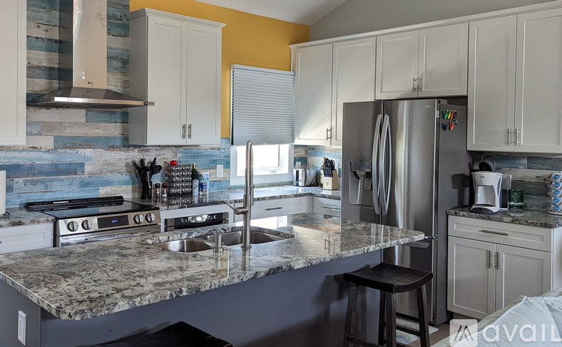 A kitchen with a granite countertop and stainless steel appliances.