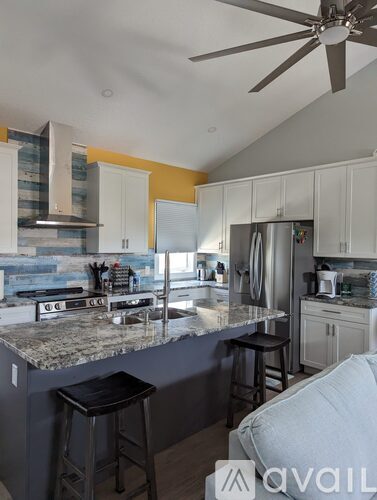 A kitchen with a bar area and a ceiling fan.