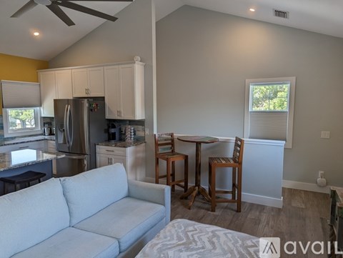 A kitchen with a refrigerator, a table with chairs, and a couch.