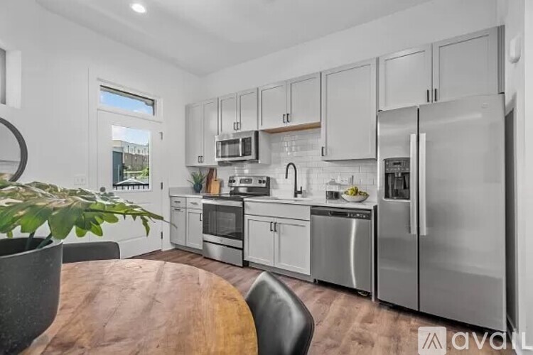 A kitchen with stainless steel appliances and white cabinets.