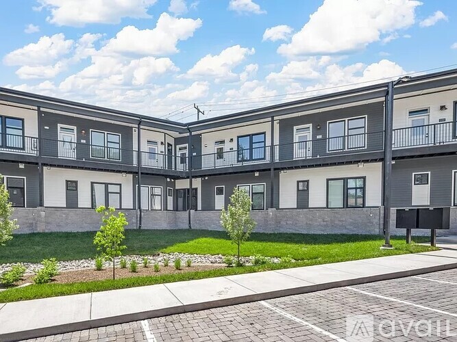 A row of modern townhouses with a grassy front yard.