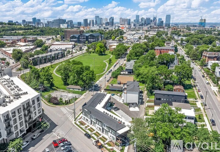 A bird's eye view of a city with buildings, roads, and green spaces.